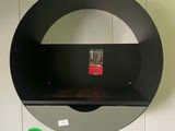 une étagère noire surmontée d'un miroir accroché au mur