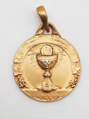 un gros plan d'une médaille d'or sur laquelle figure un calice