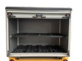 a yellow truck that has a rack with black trays on it