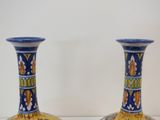two blue and yellow vases sitting on a table