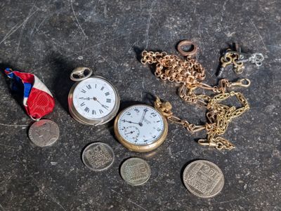 a lot of coins and a pocket watch on a table