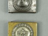 two silver and gold metal buttons with a crown on them