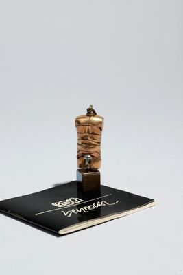 une petite statue représentant une personne enroulée dans une corde
