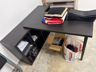 un bureau noir avec un tiroir en dessous, dans une pièce