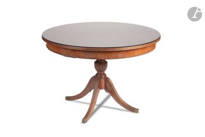 une table ronde avec un piètement en bois et un plateau en verre