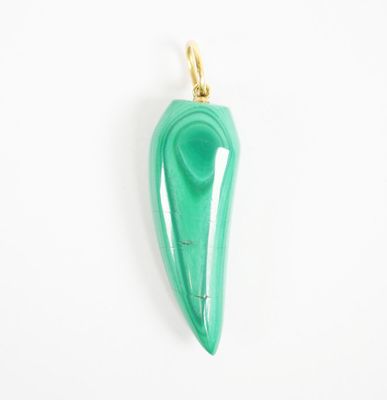 a close up of a green pendant on a white surface