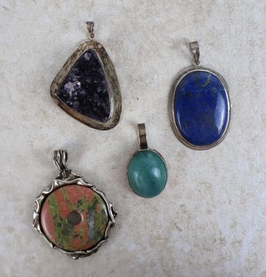 trois pendentifs de couleurs et de formes différentes sur une surface blanche