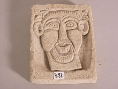 une sculpture en pierre représentant le visage d'un homme, exposée