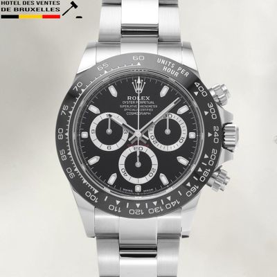 a close up of a watch with a black dial and a silver bracelet