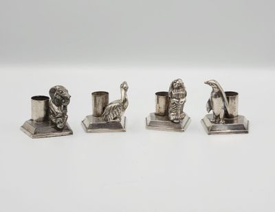 trois figurines en argent représentant des animaux et un oiseau, posées sur un socle