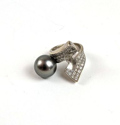 bague en argent avec une perle noire et des diamants sur fond blanc