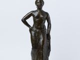 une statue en bronze représentant une femme portant un pot sur la tête