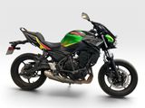 a green and black motorcycle parked on a white surface