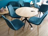tables and chairs in a room with blue walls and wood flooring