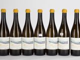 six bouteilles de vin sont alignées dans une rangée