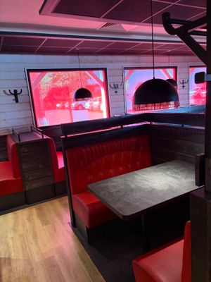 une cabine avec une table et des banquettes rouges dans la pièce