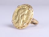 a close up of a gold coin ring on a white surface