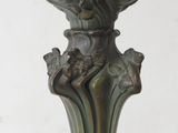 a green vase on a stand with a gold handle