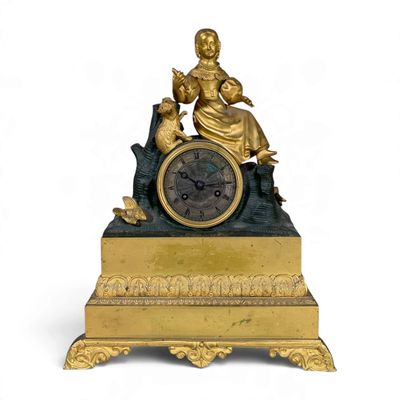 a gold clock with a statue on top of it