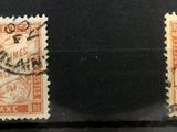 Trois timbres de couleurs différentes sont exposés dans une vitrine.
