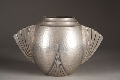 a silver vase that is sitting on a table
