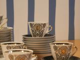 many cups and saucers sitting on a wooden table