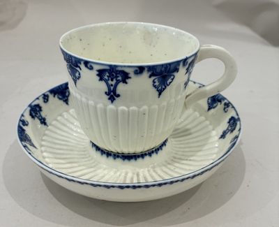 une tasse et une soucoupe bleues et blanches posées sur une table