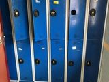 several blue lockers are lined up in a room with a red door
