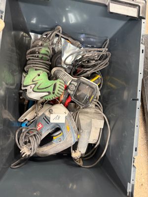 a metal container filled with assorted tools on the floor