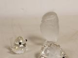 deux figurines en verre transparent posées sur une table