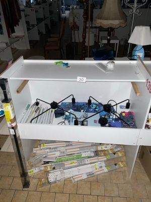 une étagère blanche sur laquelle sont posés tout un tas d'objets
