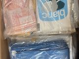 a cardboard box filled with clothing and a bag of toilet paper