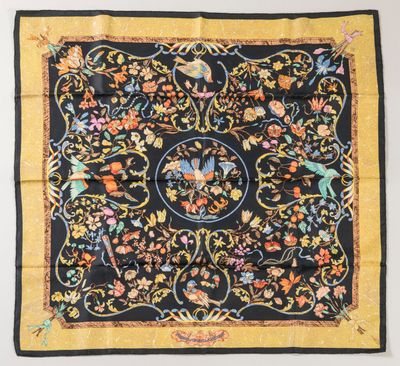 a black and yellow silk scarf with a floral design