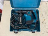 a blue box with a drill and a cord in it