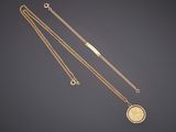 a gold necklace with a coin on a chain