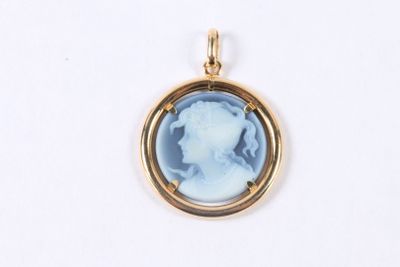 a close up of a pendant with a woman ' s face in a gold frame