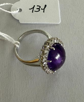 an image of a ring with a purple stone surrounded by white diamonds
