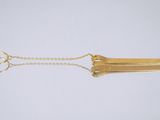 un collier plaqué or composé d'une barre et d'une chaîne