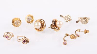 plusieurs paires de boucles d'oreilles en or et en perles posées sur un fond blanc