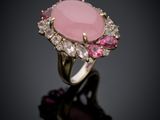 a close up of a pink stone ring on a black surface