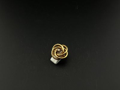 a close up of a gold and silver ring on a black surface