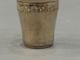 a silver cup sitting on a table with a white background