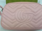 a pink purse with a chain strap and a logo on it