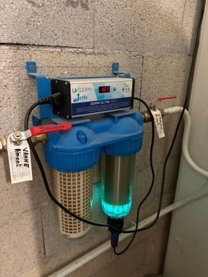 un filtre à eau fixé au mur à côté d'un chauffe-eau