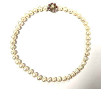 un gros plan sur un collier de perles blanches orné d'une fleur rouge