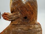 a wooden sculpture of a bird that is sitting on a piece of wood