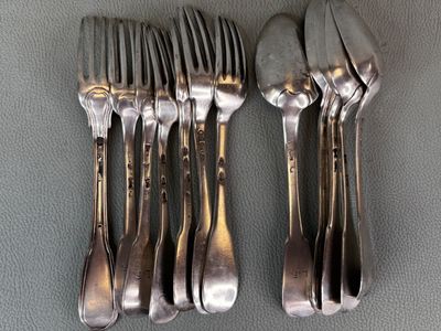 five forks and two spoons sitting on a table
