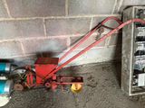 une petite machine rouge posée à côté d'un mur de briques