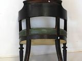 a black chair with a green seat in a room