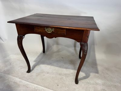 une vieille table en bois surmontée d'un tiroir